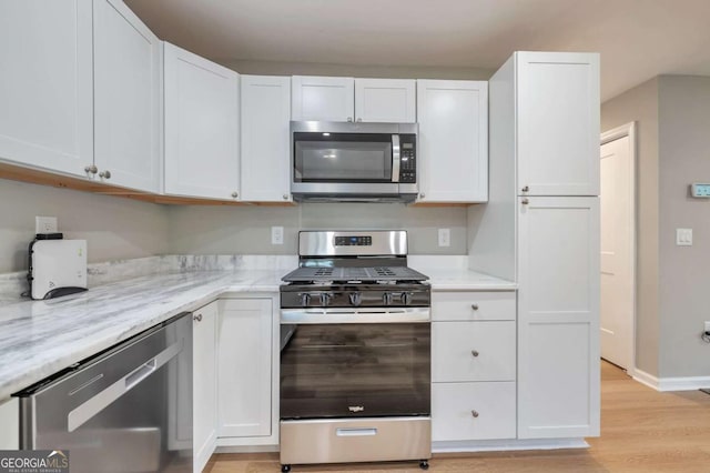 3650 Clovis Ct NW, Atlanta, GA 30331 - kitchen featuring white cabinetry, light wood-type flooring, stainless steel appliances, baseboards, and light stone counters