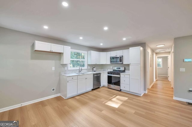 3650 Clovis Ct NW, Atlanta, GA 30331 - kitchen featuring light countertops, light wood-style flooring, stainless steel appliances, baseboards, and white cabinets