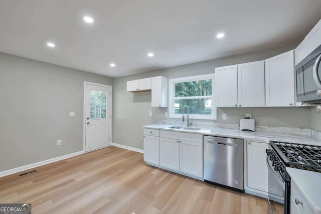 3650 Clovis Ct NW, Atlanta, GA 30331 - kitchen featuring white cabinets, visible vents, light wood-style flooring, stainless steel appliances, and a sink