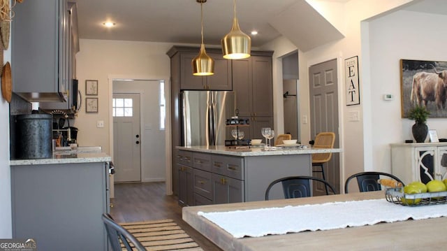 201 Huntington Pl, Dahlonega, GA 30533 - kitchen featuring freestanding refrigerator, a kitchen island, wood finished floors, decorative light fixtures, and light stone countertops
