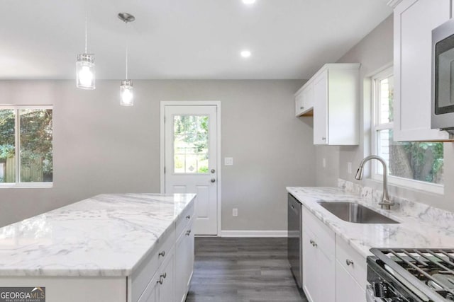 kitchen featuring a wealth of natural light, a sink, stainless steel appliances, and light stone counters