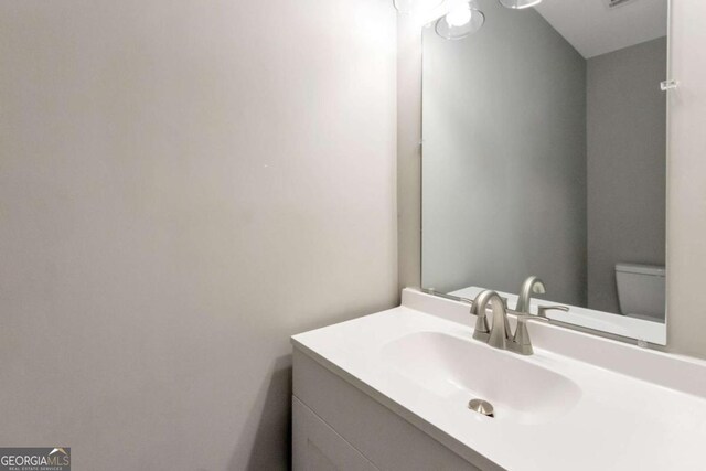 half bath featuring toilet and vanity