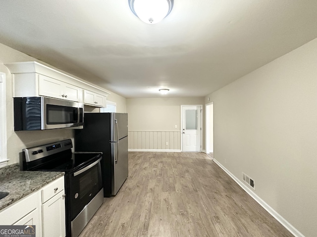 518 Hammett Dr, Decatur, GA 30032 - kitchen with visible vents, light stone countertops, stainless steel appliances, white cabinetry, and light wood-type flooring