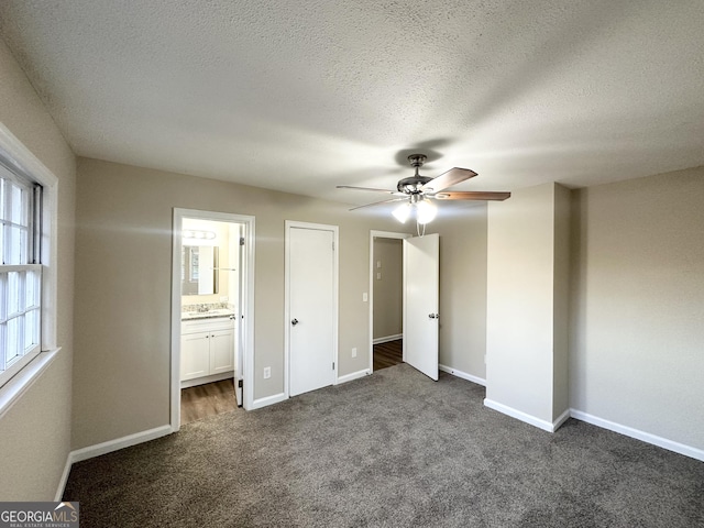 518 Hammett Dr, Decatur, GA 30032 - unfurnished bedroom with dark colored carpet, baseboards, a textured ceiling, ensuite bath, and ceiling fan