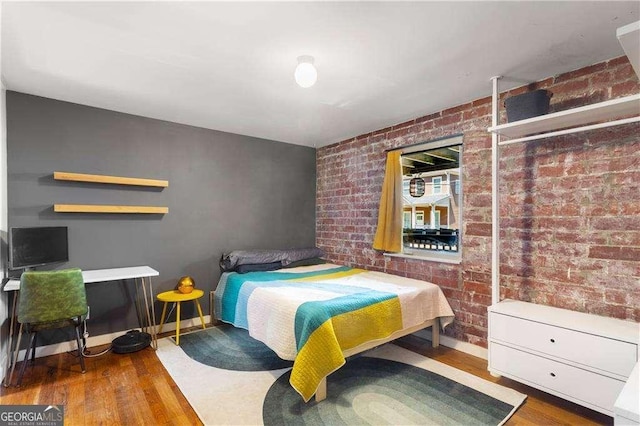 562 Formwalt St SW Unit 5, Atlanta, GA 30312 - bedroom with baseboards, brick wall, and wood finished floors