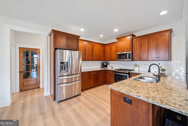 2442 Lower Union Hill Rd, Canton, GA 30115 - kitchen with appliances with stainless steel finishes, light stone counters, brown cabinets, light wood-style floors, and recessed lighting