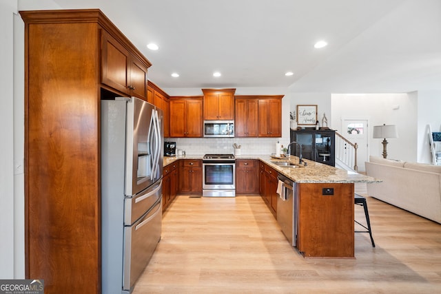 2442 Lower Union Hill Rd, Canton, GA 30115 - kitchen featuring appliances with stainless steel finishes, light wood finished floors, a kitchen breakfast bar, open floor plan, and a peninsula