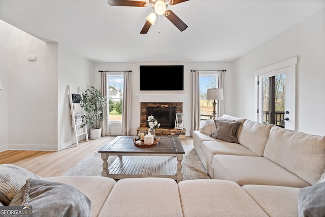 2442 Lower Union Hill Rd, Canton, GA 30115 - living room with light wood-style floors, ceiling fan, and a fireplace