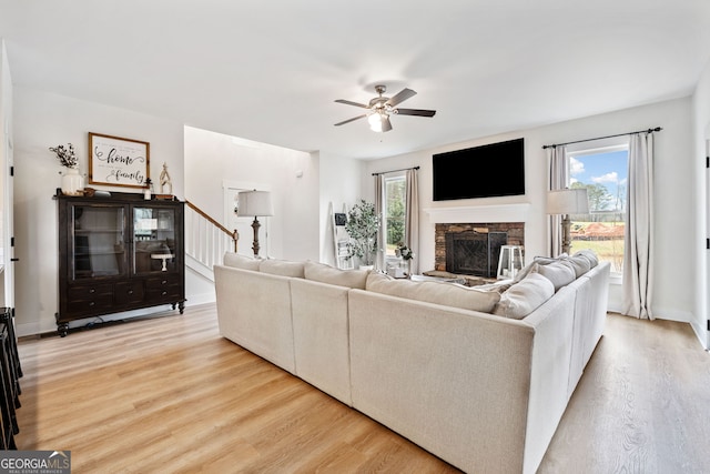 2442 Lower Union Hill Rd, Canton, GA 30115 - living area featuring light wood-type flooring, a stone fireplace, ceiling fan, baseboards, and stairway