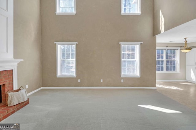 2983 Bancroft Gln NW, Kennesaw, GA 30144 - unfurnished living room with carpet floors, a brick fireplace, a high ceiling, and plenty of natural light