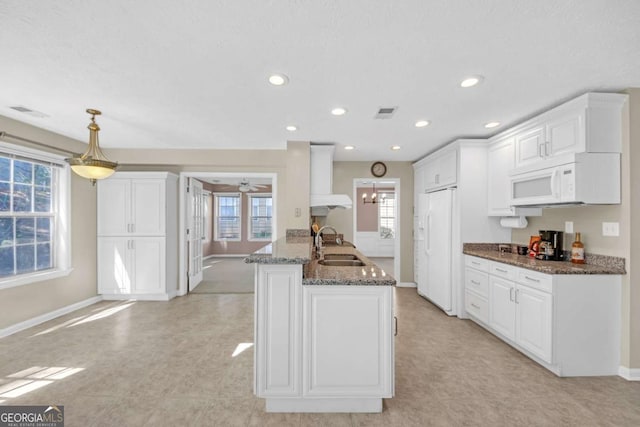 2983 Bancroft Gln NW, Kennesaw, GA 30144 - kitchen with wall chimney exhaust hood, white appliances, white cabinets, dark stone counters, and recessed lighting