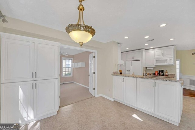 2983 Bancroft Gln NW, Kennesaw, GA 30144 - kitchen featuring white appliances, recessed lighting, white cabinets, light stone countertops, and a peninsula