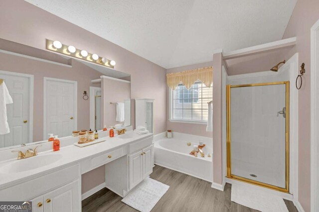 2983 Bancroft Gln NW, Kennesaw, GA 30144 - bathroom featuring a garden tub, wood finished floors, a stall shower, and vaulted ceiling