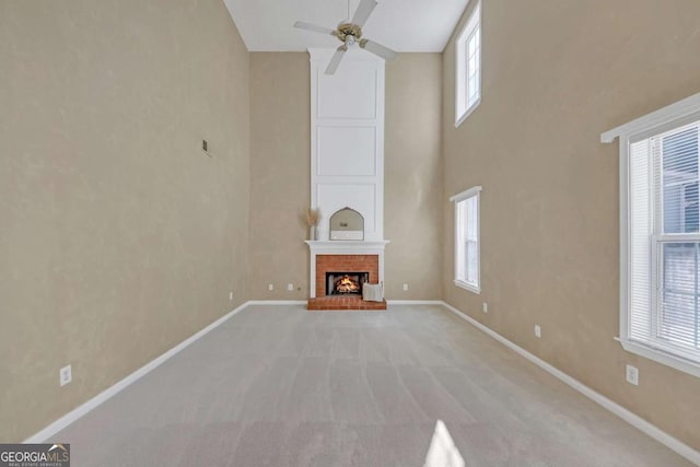 2983 Bancroft Gln NW, Kennesaw, GA 30144 - unfurnished living room with a ceiling fan, healthy amount of natural light, high vaulted ceiling, light carpet, and a brick fireplace