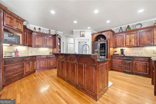 kitchen with stainless steel refrigerator with ice dispenser, ornamental molding, a breakfast bar area, light wood-style floors, and tasteful backsplash