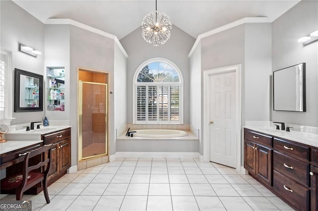 bathroom featuring a stall shower, a garden tub, lofted ceiling, two vanities, and a chandelier