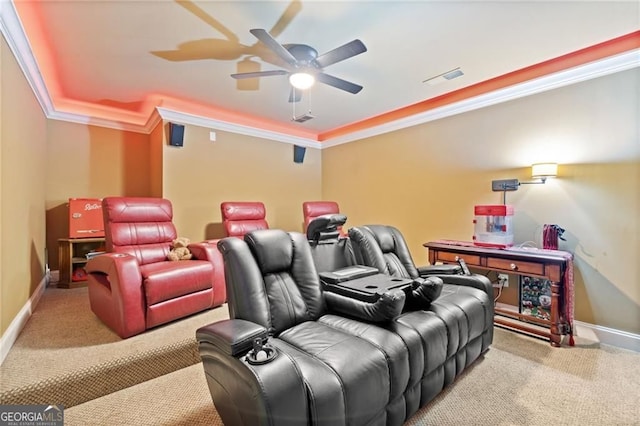 carpeted home theater room with crown molding, a ceiling fan, and baseboards