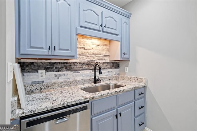 kitchen with dishwasher, a sink, decorative backsplash, and light stone countertops
