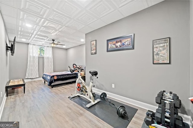 workout area featuring ceiling fan, baseboards, and wood finished floors