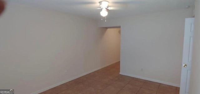 unfurnished room with a ceiling fan, light tile patterned floors, and baseboards