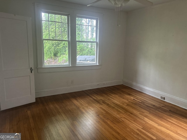 spare room featuring baseboards, ceiling fan, and wood-type flooring