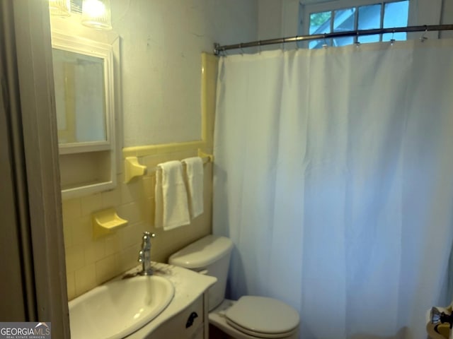 3776 Berkley Dr, Macon, GA 31204 - bathroom featuring toilet, vanity, a shower with curtain, tile walls, and decorative backsplash