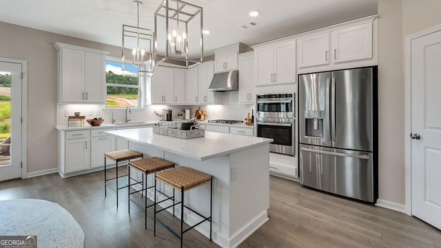 52 Sheryl Way, Loganville, GA 30052 - kitchen featuring appliances with stainless steel finishes, under cabinet range hood, plenty of natural light, light wood-style flooring, and recessed lighting