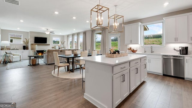 52 Sheryl Way, Loganville, GA 30052 - kitchen with dishwasher, recessed lighting, a center island, wood finished floors, and a fireplace