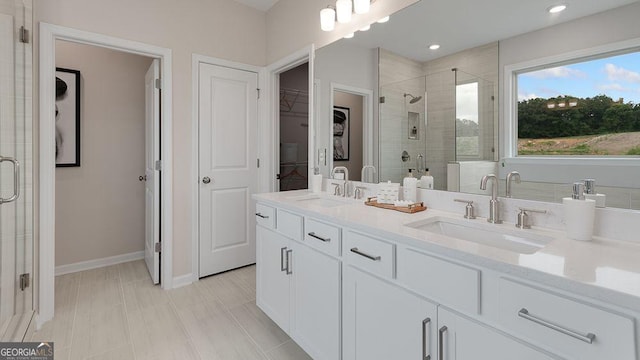 52 Sheryl Way, Loganville, GA 30052 - bathroom with a shower stall, a walk in closet, double vanity, and recessed lighting