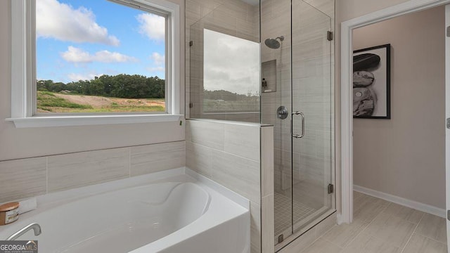 52 Sheryl Way, Loganville, GA 30052 - bathroom featuring a stall shower, a garden tub, and plenty of natural light
