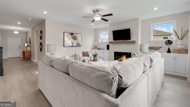 52 Sheryl Way, Loganville, GA 30052 - living room featuring a fireplace, ceiling fan, recessed lighting, healthy amount of natural light, and light wood-style floors