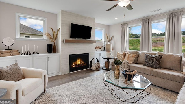 52 Sheryl Way, Loganville, GA 30052 - living area with a tiled fireplace, light wood finished floors, ceiling fan, and recessed lighting