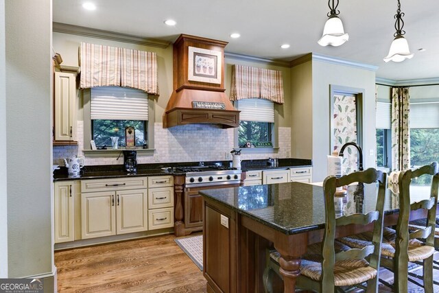 2373 Herman Drake Rd, Young Harris, GA 30582 - kitchen with decorative backsplash, light wood finished floors, a breakfast bar, stainless steel gas cooktop, and ornamental molding