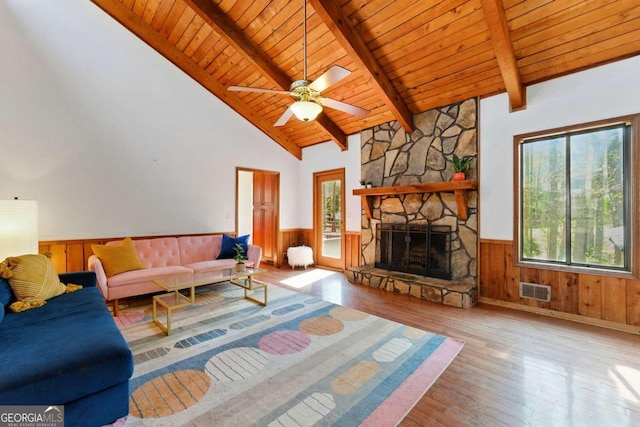 unfurnished living room with wooden ceiling, beam ceiling, wood finished floors, wainscoting, and visible vents