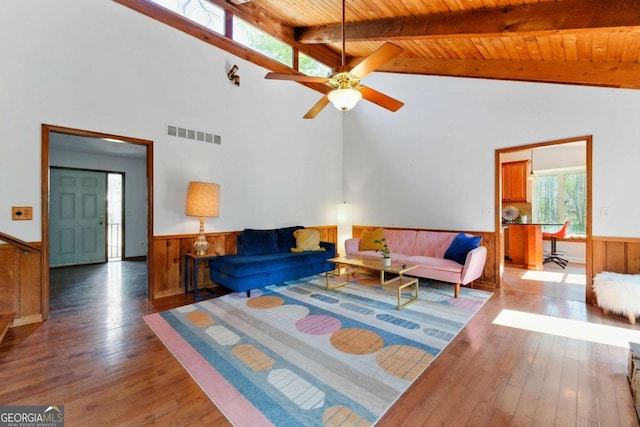 living room featuring a wainscoted wall, vaulted ceiling with beams, visible vents, and wood ceiling