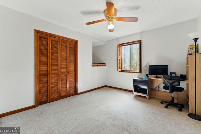 home office with baseboards, a textured ceiling, carpet floors, and a ceiling fan