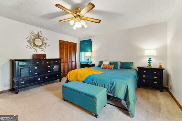 bedroom featuring carpet, baseboards, a textured ceiling, ceiling fan, and a closet