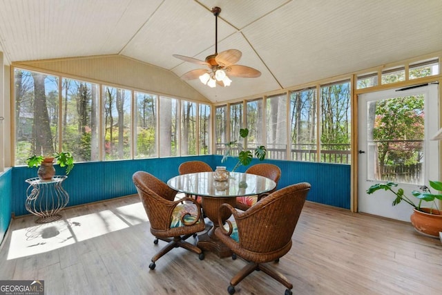 sunroom / solarium featuring vaulted ceiling, a wooden deck, wood finished floors, and a ceiling fan