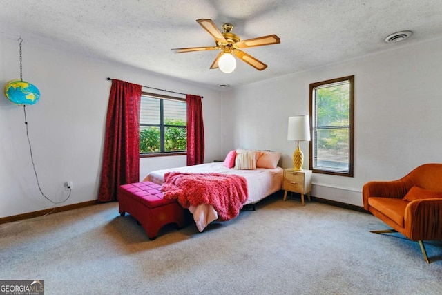 bedroom with carpet flooring, a textured ceiling, baseboards, and visible vents