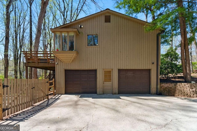 garage featuring driveway and fence