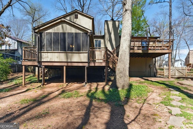 back of house with a sunroom, fence, a gate, stairs, and a deck