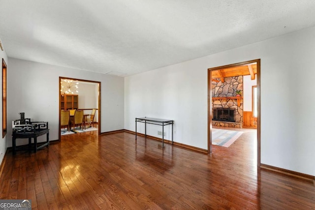 unfurnished room featuring baseboards, a fireplace, and wood-type flooring