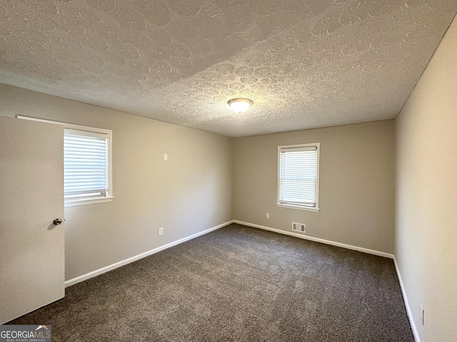 2317 Emerald Springs Dr, Decatur, GA 30035 - empty room featuring baseboards, a textured ceiling, visible vents, and dark colored carpet