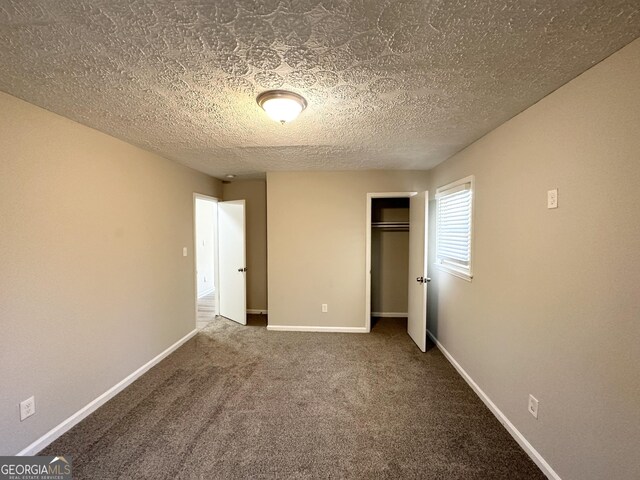 2317 Emerald Springs Dr, Decatur, GA 30035 - unfurnished bedroom featuring carpet floors, baseboards, a closet, and a textured ceiling