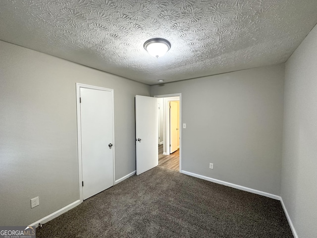 2317 Emerald Springs Dr, Decatur, GA 30035 - unfurnished bedroom with baseboards, carpet floors, and a textured ceiling
