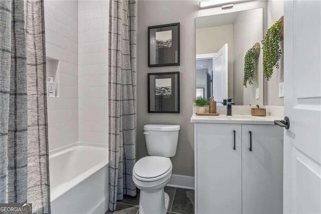 bathroom featuring shower / tub combo, toilet, vanity, and baseboards