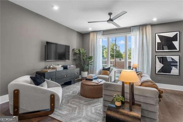 living room with baseboards, a ceiling fan, and wood finished floors