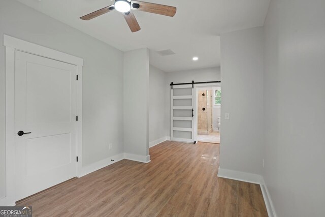 1441 Ezra Church Dr NW, Atlanta, GA 30314 - interior space featuring baseboards, a barn door, visible vents, light wood-style flooring, and ceiling fan