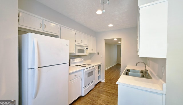 2929 Torreya Way SE, Marietta, GA 30067 - kitchen featuring white appliances, a sink, wood finished floors, white cabinetry, and recessed lighting