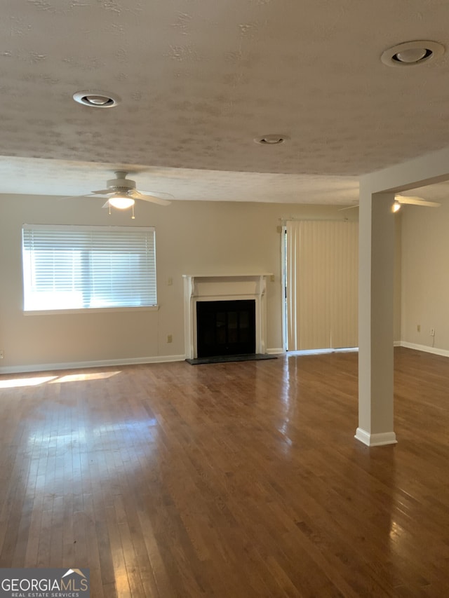 2929 Torreya Way SE, Marietta, GA 30067 - unfurnished living room with hardwood / wood-style floors, ceiling fan, a fireplace with raised hearth, and baseboards